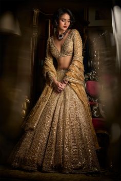 This lehenga set features heavy gold embroidery in a linear pattern. The full sleeves blouse has a plunging neckline. The lehenga set shows delicate pearl, gold beaded detail at the neckline, waist and wrist. It is paired with a fully embroidered dupatta. DELIVERY TIMEPlease allow 8-12 weeks for your outfit to arrive. FABRIC DETAILSLehenga - Net / Dupatta - Net Professional cleaning only. Beaded Lehenga, Scallop Dupatta, Maroon Dupatta, Seema Gujral, Gold Lehenga, Crystal Work, Full Sleeve Blouse, Crystal Embroidery, Green Lehenga