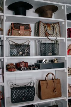 several purses and handbags are on shelves in a closet with white shelving