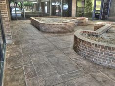 an empty courtyard with brick walls and steps leading up to the front door, surrounded by glass doors