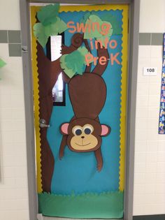 a classroom door decorated to look like a monkey hanging from a tree with the words swing into prek on it