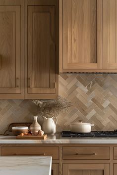 a kitchen with wooden cabinets and marble counter tops, along with a white vase filled with flowers