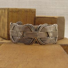 "Handmade sterling silver wire cuff bracelet. The inside measures 7\" including the 1 3/16\" opening. 1\" wide. 18 strands of wire are held together by a decorative wovern vertical pattern. Tested and verified to be sterling silver. Good condition. Unique bracelet. SBT-5" Handwoven Cuff Bangle Bracelet As Gift, Handwoven Bangle Cuff Bracelet As Gift, Elegant Handwoven Silver Jewelry, Adjustable Interwoven Bracelets As Gift, Artisan Handwoven Silver Jewelry, Artisan Silver Bangle Hand Wrapped, Artisan Silver Hand Wrapped Cuff Bracelet, Artisan Hand Wrapped Silver Cuff Bracelet, Artisan Hand-wrapped Silver Cuff Bracelet