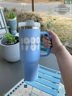 a person holding a blue coffee cup on top of a table