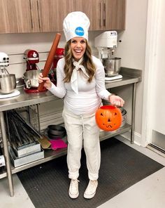 a woman in a chef's hat holding an orange pumpkin