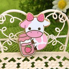 a pink and white giraffe holding a strawberry in it's mouth on top of a chair