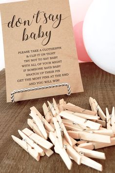 wooden clothes pins are on the table next to a sign that says don't say baby