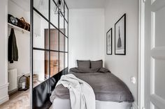 a bed sitting in a bedroom next to a window with pictures on the wall above it