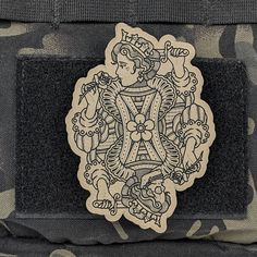 a patch on the back of a camo bag with an image of a woman