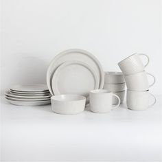 white dishes and cups are stacked on top of each other