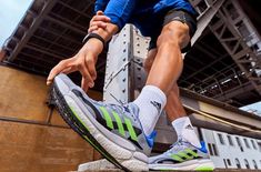 a man tying his running shoes on the side of a building