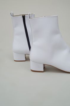 Square Toe ankle boot in White faux calf with metal zipper on inside ankle. Final Sale Info & Care 100% Polyester Velvet Handmade in Portugal Vegan Size & Fit Whole sizes only, runs true to size, (size up if between sizes) 40mm Block Heel Returns & Exchanges New and unused full-price merchandise returned 14 days after receipt is eligible for refund or exchange. Discounted merchandise is final sale. Luxury White Square Toe Boots, Chic White Square Toe Mid-calf Boots, White Pointed Toe Mid-calf Boots In Faux Leather, White Ankle-high Boots With Sculpted Heel, White Boots With Sculpted Heel, Medium Width, Cutout Ankle Boots, Square Toe Ankle Boots, Fishtail Parka, Unique Hardware