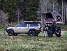 a truck with a tent attached to it parked in the grass