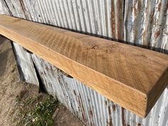 a wooden shelf sitting on top of a metal wall