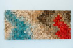 a piece of art made out of wood with red and blue squares on the side