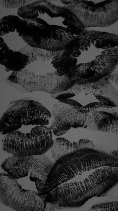 black and white photograph of many different types of lip prints on a sheet of paper