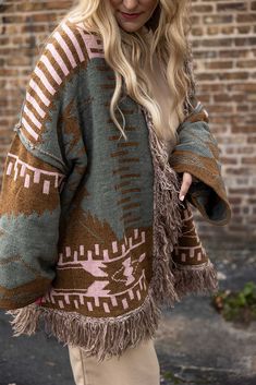 introducing the perfect cozy staple for the season—the lottie cardi in olive mocha! soft chenille fabric with an oversized fit combined with stunning aztec and tribal patterns make this cardi an eye-catching, yet comfortable style. the open front design and long sleeves makes this cardi your go-to layer. fringe detailing on the hem adds the perfect finishing touch to this must-have look. amber is wearing a small, jackie is wearing a large s 0-8 m 8-12 l 12-18 100% polyester Bohemian Brown Sweater Coat For Fall, Bohemian Cardigan For Cold Weather, Oversized Brown Bohemian Sweater, Cow Print Cardigan, Bohemian Fringe Winter Cardigan, Eyelash Southwestern Sweater Cardigan, Oversized Brown Bohemian Cardigan, Aztec Print Cardigan, Comfortable Style