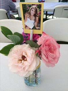 a vase filled with flowers sitting on top of a table next to a photo frame