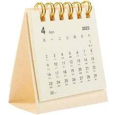 a desk calendar with gold spirals on it