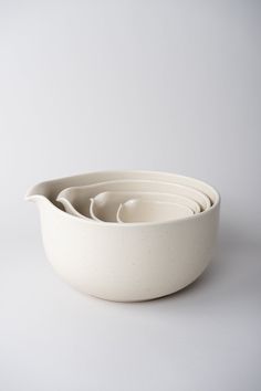 four white bowls stacked on top of each other