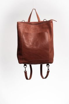 "The Andes is an unlined spacious convertible leather backpack. The generous exterior pocket allows you to keep your wallet and phone handy at all times. The leather straps can easily switch between positions, transforming the backpack into a satchel-tote, so you can use the bag in two different ways. Handcrafted by artisans in Argentina, and made with full-grain vegetable-tanned leather dyed with natural pigments respecting the environment. Height: 16\" Width at the top: 12\" Width at the bottom: 15\" Depth: 4.5\" Length of Straps: 28\" Fits a 15\" laptop, and much more!" Leather Designs, Handmade Backpacks, Leather Ideas, Natural Pigments, Satchel Backpack, Leather Duffle Bag, Leather Dye, Leather Duffle, Convertible Backpack