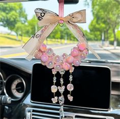 a car dashboard decorated with pink beads and bows