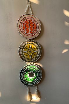 three circular glass ornaments hanging on a wall