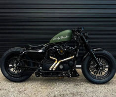 a black and green motorcycle parked in front of a garage door