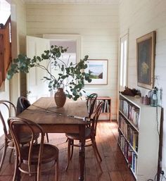 a dining room table with chairs and a potted plant on top of the table