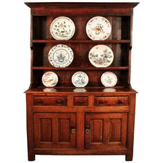 an old wooden china cabinet with plates on it