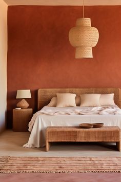 A modern bedroom with terracotta walls and a textured white ceiling. The room features a bed with a tufted terracotta headboard, terracotta and white linens, a wooden nightstand, and a terracotta textured lamp. A terracotta and white textured rug and a terracotta macramé wall hanging add layers of texture. Desert Tone Bedroom, Mexican Modernism Bedroom, Amsterdam Bedroom, Bedroom Terracotta, Terracotta Bedroom Ideas, Mexican Bedroom Ideas, Mexican Bedroom, Terracotta Bedroom, Peach Bedroom