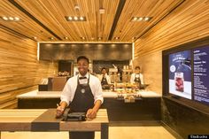 a man standing behind a counter in a restaurant