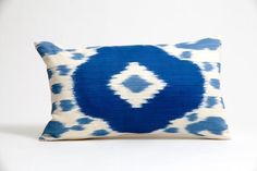 a blue and white pillow on a white background