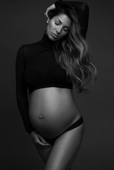 a pregnant woman is posing for a black and white photo