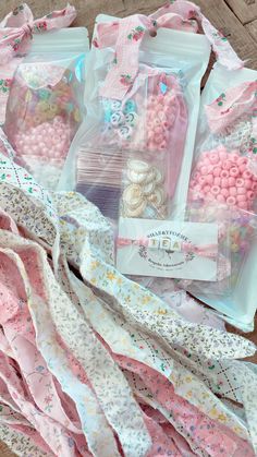 several bags filled with pink and white candies sitting on top of a wooden table