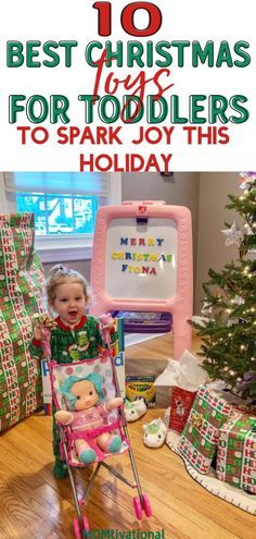 a baby in a stroller with presents on the floor and christmas tree behind it