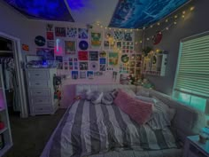 a bed room with a neatly made bed and lots of pictures on the wall