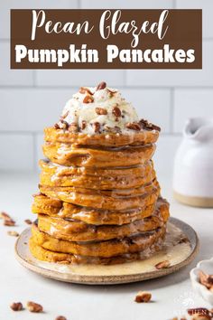 a stack of pumpkin pancakes with whipped cream on top and pecans around the edges