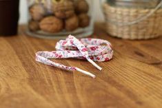 a pair of white and red flowered cotton twine on top of a wooden table