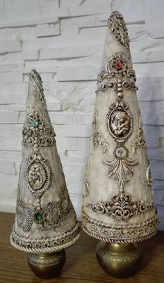 two white ceramic christmas trees sitting on top of a wooden table