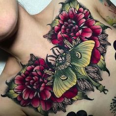 a close up of a woman's chest with flowers and a butterfly on it