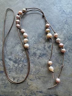 I made this necklace using bronze colored leather, strung with different sizes Baroque pearls, tied together about 18" down, total length is 26".  All my jewelry comes in a hand painted box. My jewelry is unique, no two pieces are alike but some are similar.  I love using different metals, sterling silver, brass and copper; and mixing various beads, pearls, semi-precious, glass, wood, antique and repurposed.   💙 Elegant Brown Necklace With Adjustable Cord, Adjustable Brown Lariat Necklaces, Brown Necklace With Adjustable Chain, Brown Spiritual Necklace With Adjustable Length, Brown Spiritual Necklaces With Adjustable Length, Artisan Brown Jewelry With Sliding Knot, Adjustable Brown Long Lariat Necklace, Brown Lariat Necklace With Adjustable Length, Brown Lariat Necklace For Gift