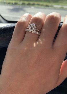 a woman's hand on the steering wheel of a car with a diamond ring