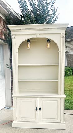 a white bookcase sitting on top of a sidewalk