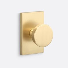 an image of a gold door knob on a white wall with the handle pointing towards it