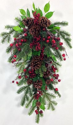 a bunch of pine cones and berries hanging on a wall