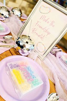 a table topped with lots of pink plates and silverware covered in confetti