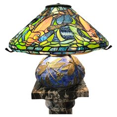 a table lamp that is sitting on top of a marble base with a colorful glass shade