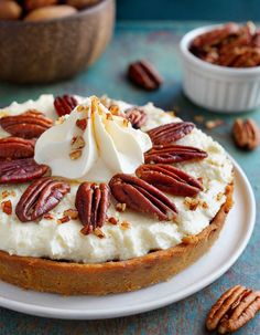 a cake with pecans around it on a plate