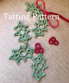 two crocheted ornaments are sitting on the floor next to a red ribbon and thread