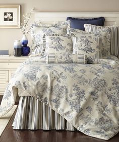 a bed with blue and white comforters in a bedroom